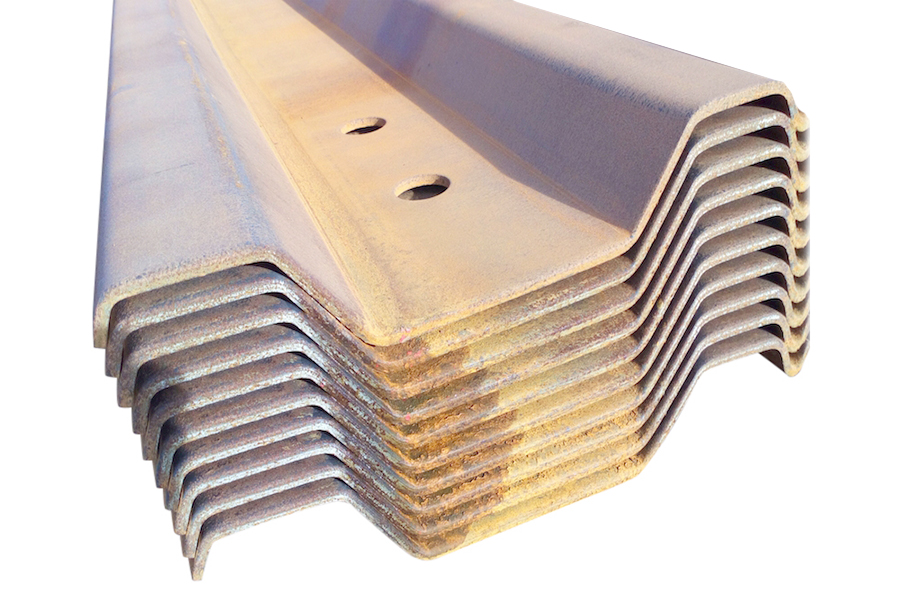 Overlapping and interlocking steel trench sheets stacked on a groundworks site