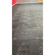 Wide view of gym floor fitted with interlocked black floor protection mats, displaying HERMEQ logo and non-slip diamond texture.