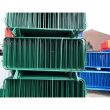 Front-facing view of green barriers, showing dense packing and welded vertical bars.
