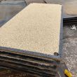 Anti-skid trench plates stacked in an industrial yard with bauxite stone non-skid finish for temporary ground protection