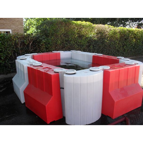 Modular Floodstop barrier system creating water containment area with red and white interlocking units