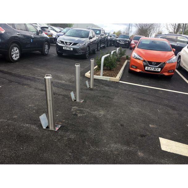 Installed retractable parking bollards in car park providing secure access control and protection for vehicles and reserved spaces.