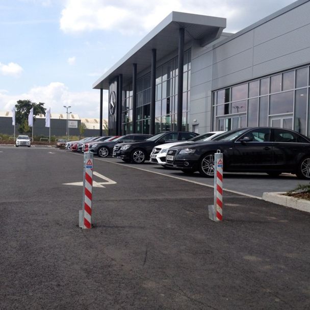 Retractable parking posts with reflective stripes, providing high-visibility access control and vehicle security for commercial sites.